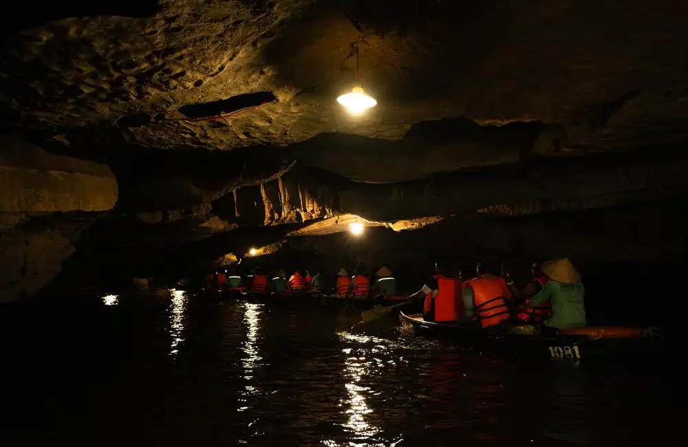 sampan boat take travelers into grotto in Trang An