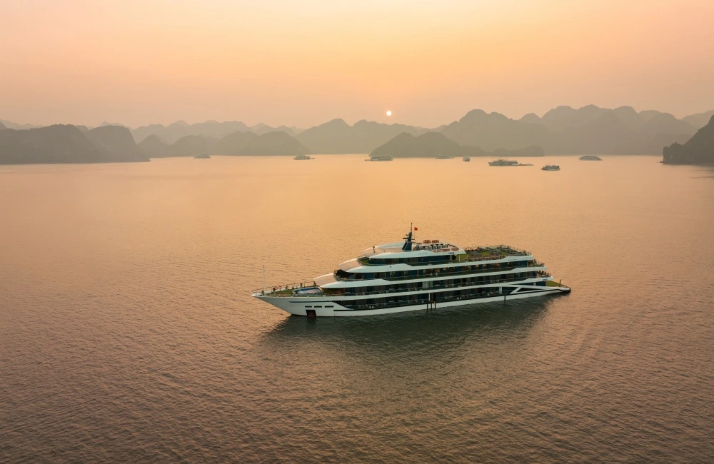 Luxury cruise sailing under sunset in Halong Bay