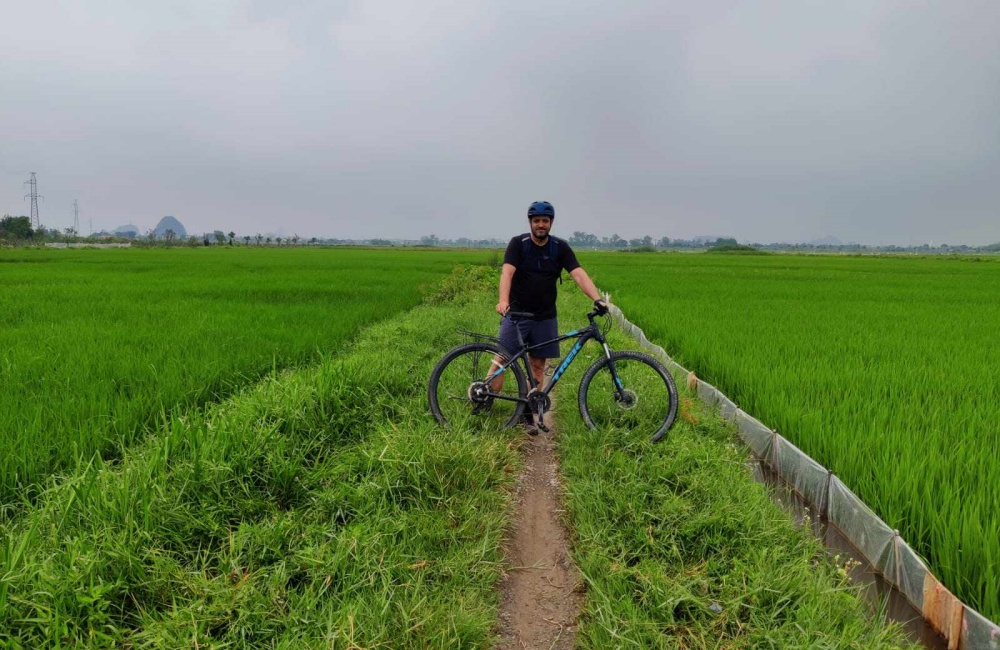 Travelers with bike in Ninh Binh rice fields